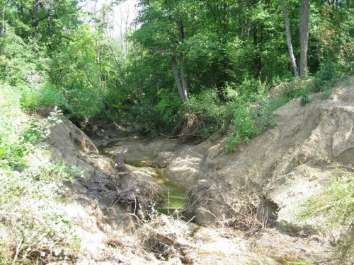 Промытый водным потоком после прорванной плотины овраг