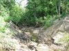 Промытый водным потоком после прорванной плотины овраг