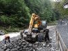 Рабочие-гастарбайтеры бросают камни в ковш экскаватора для его последующей отсыпки в габионы