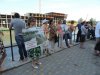 Жители держат плакаты на фоне стройки