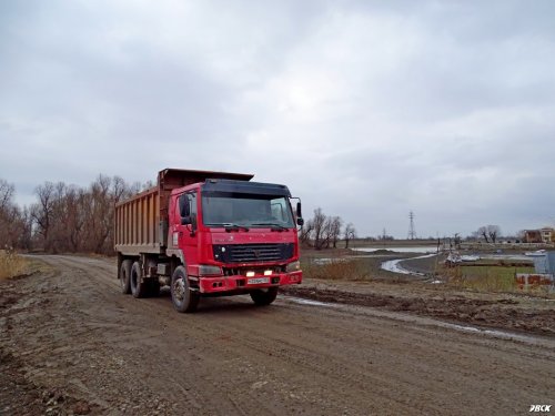 Движение большегрузного транспорта по незаконно построенной дамбе через старицу реки Кубань