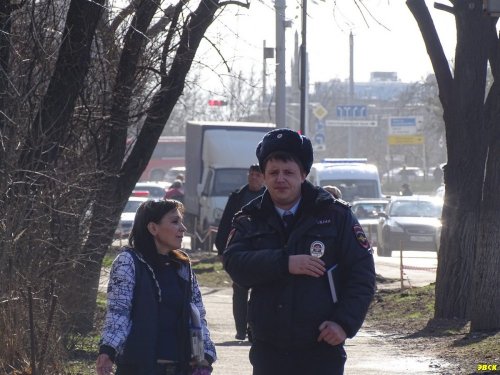 Находящиеся на месте рубки чиновница и полицейский явно не понимают, почему жители так активно выступают против вырубки деревьев