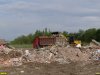 Погрузчик загружает мусором автомобиль