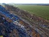 Вид с мусорной горы на залепленную разлетающимися со свалки пакетами лесополосу