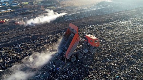 Старый мусор с участка, расчищаемого под "перегрузочную площадку", вывозится наверх существующей свалки