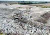 Бульдозер "растягивает" свежие отходы по поверхности официально закрытой свалки ТКО