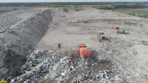 Мусоровоз выгружает свежий мусор на официально закрытой Динской свалке ТКО